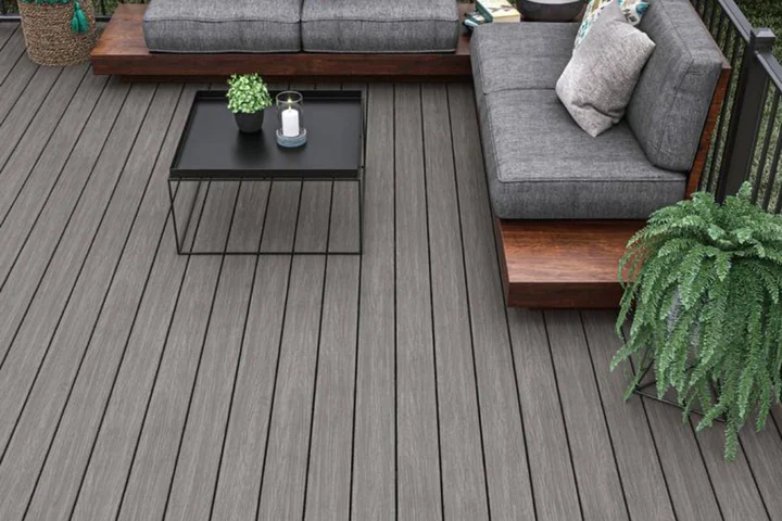 Grey WPC deck with a corner sofa, planter and black railing